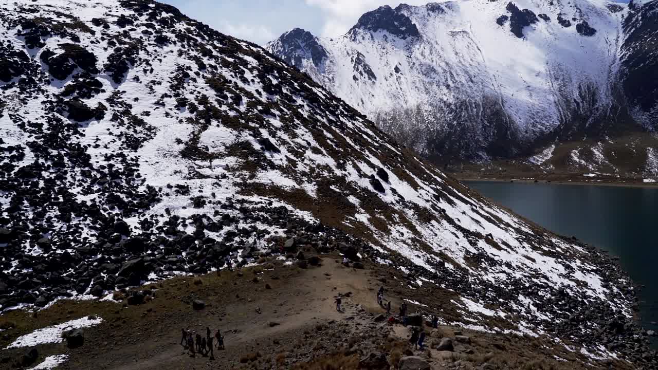 View of the nevado de toluca volcano also called xinantecatl and it's main lagoon also a far view of the tourists that visit the xinantecatl when snow falls