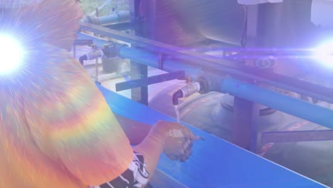 Animation-of-lights-and-lens-flare-over-african-american-woman-washing-hands-outdoors-at-standpipe