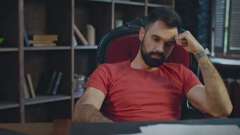 upset businessman sitting in office at evening. sad businessman thinking
