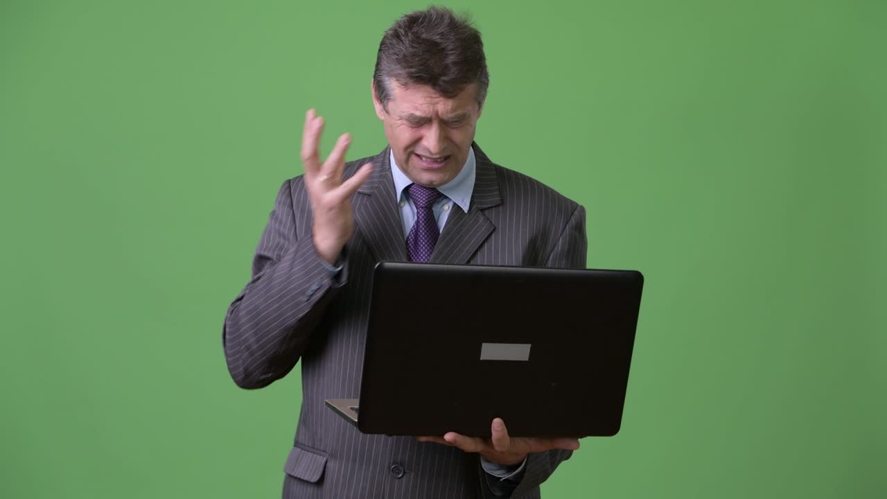 hombre de negocios maduro y guapo contra un fondo verde