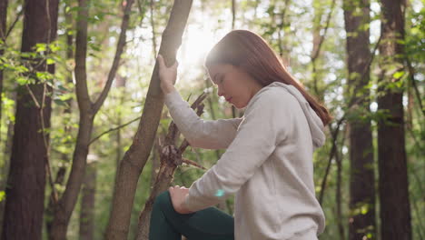 공원에서 조을 한 후 구부러진 다리를 는 젊은 여성. 자연에서 달린 후 근육을 긴장시키기 위해 스트레칭 운동을 하는 여성. 운동 후 긴장을 풀기