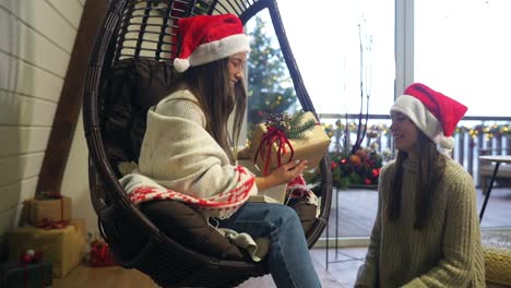 two girls exchanging christmas gifts