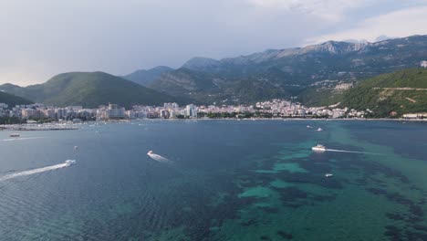 drone dolly shot toward budva riviera with lots of boat activity, montenegro