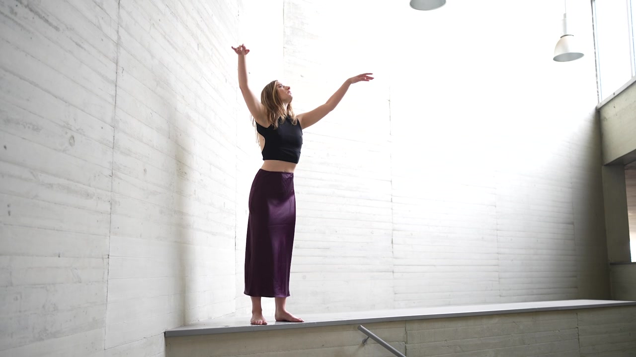 Danza contemporanea in uno spazio minimalista che esplora concetti di espressione e movimento.