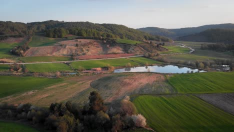 drone video over mountain lake farm fields sunset blue backround peaks distance