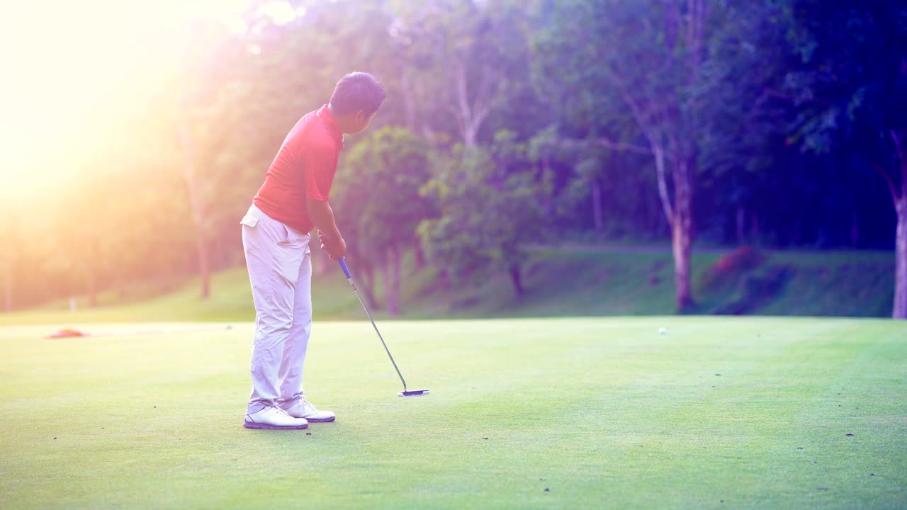 골프 스포츠 개념: 골퍼가 밝은 해가 지는 아름다운 골프 코스에서 골프 공을 구으로 던져 우승자에게.