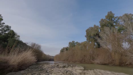 a drone glides along the guadalquivir river in southern spain