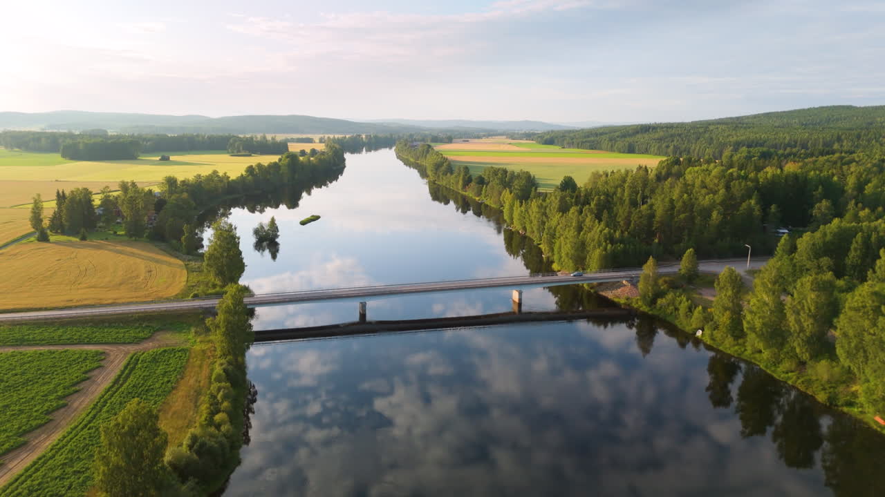 Calm Dal River with sky reflection and car driving over bridge, scenic aerial