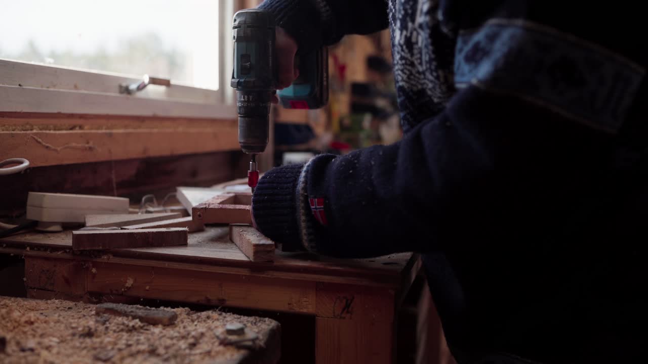 carpintero usando un destornillador inalámbrico dentro del taller
