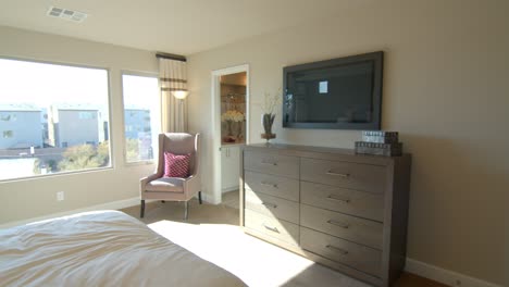 A-beautiful-bedroom-designed-with-large-glass-windows-overlooking-the-neighborhood-in-Las-Vegas,-Nevada---wide-pan-rolling