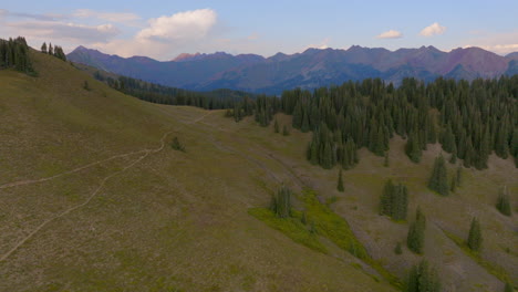 Aerial-flyover-hiking-trail-and-trees-and-towards-a-mountain-range-in-the-Rocky-Mountains-in-Colorado-on-a-beautiful-day