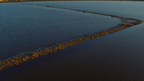 aerial view saline lake surface with salt exploration basine. sand coastline