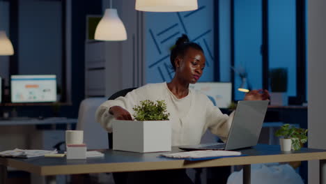 sad african fired businesswoman packing things in box being dismissed from job