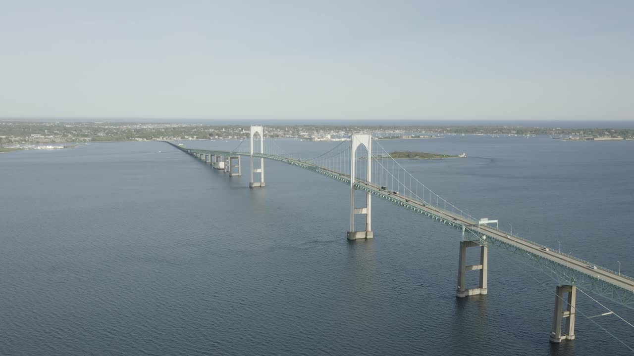 물을 가로지르는 큰 다리의 드론 샷, 앞으로 나아가고 천천히 아래로 기울어짐