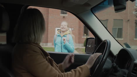 Mom-came-by-car-to-pick-up-her-daughter-from-school.-The-child-joyfully-runs-to-his-mother