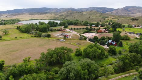 Impresionante-Video-De-Drones-Que-Muestra-El-Impresionante-Paisaje-De-Colorado-Junto-Con-Un-Lago-Y-Una-Tierra-De-Cultivo-Con-Encantadoras-Cabañas-Y-Majestuosas-Montañas.