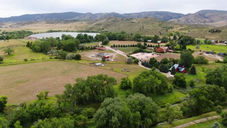impresionante video de drones que muestra el impresionante paisaje de colorado junto con un lago, y una tierra de cultivo con encantadoras cabañas, y majestuosas montañas