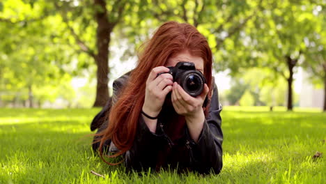 Pretty-redhead-taking-a-photo-in-the-park