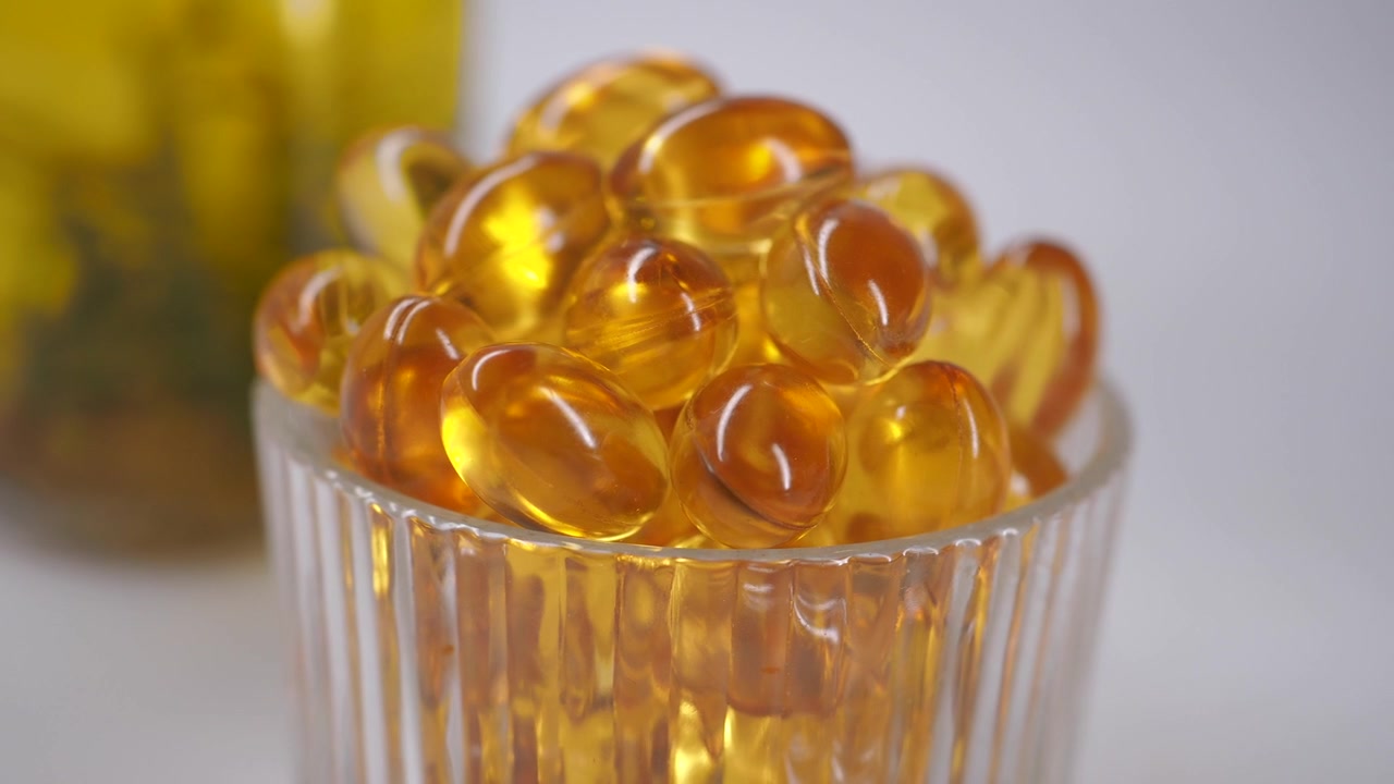 Close-up of Golden Omega-3 Fish Oil Capsules in a Glass Cup
