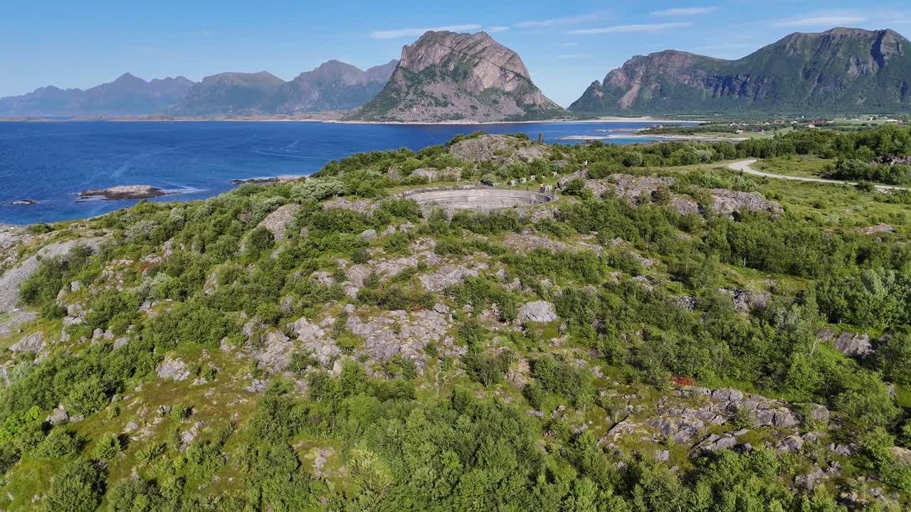 Aerial footage of Batterie Dietl on Engeløya, Norway. A historic World War II site now set on a peaceful island, surrounded by mountains and lapped by the sea