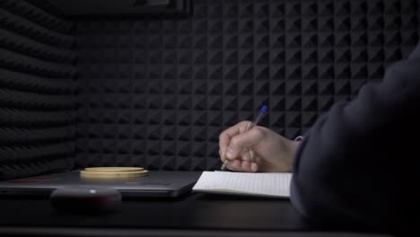 person writing in a home office soundproof room at night