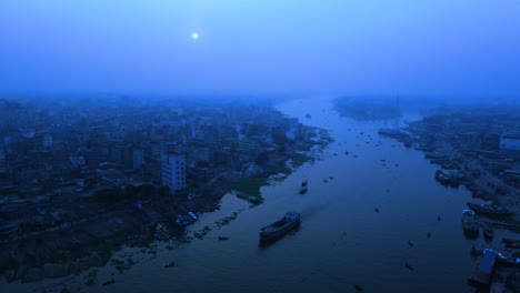 Aerial-view-of-a-riverside-city-in-a-full-moonlit-night