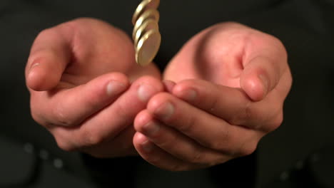 Businessman-catching-falling-coins-in-hands