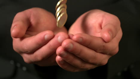 hombre de negocios atrapando monedas que caen en las manos