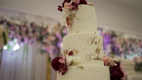 a detailed shot of a beautifully decorated wedding cake in the venue hall.