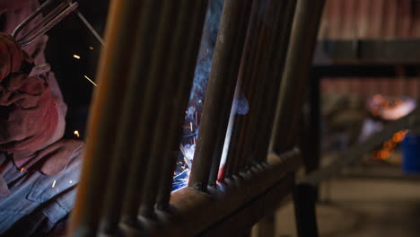 employee attaches metal pipes for boiler room with welding