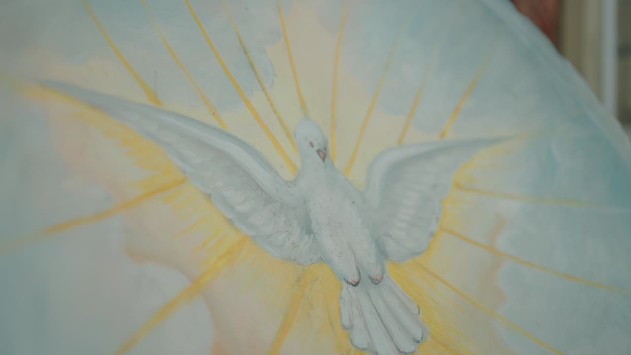 close up of painted white dove with rays symbolizing the holy spirit on soft pastel background