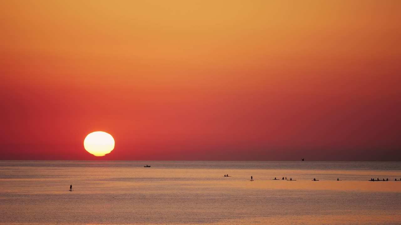 Sunrise over the Ocean with Kayakers and Paddleboarders