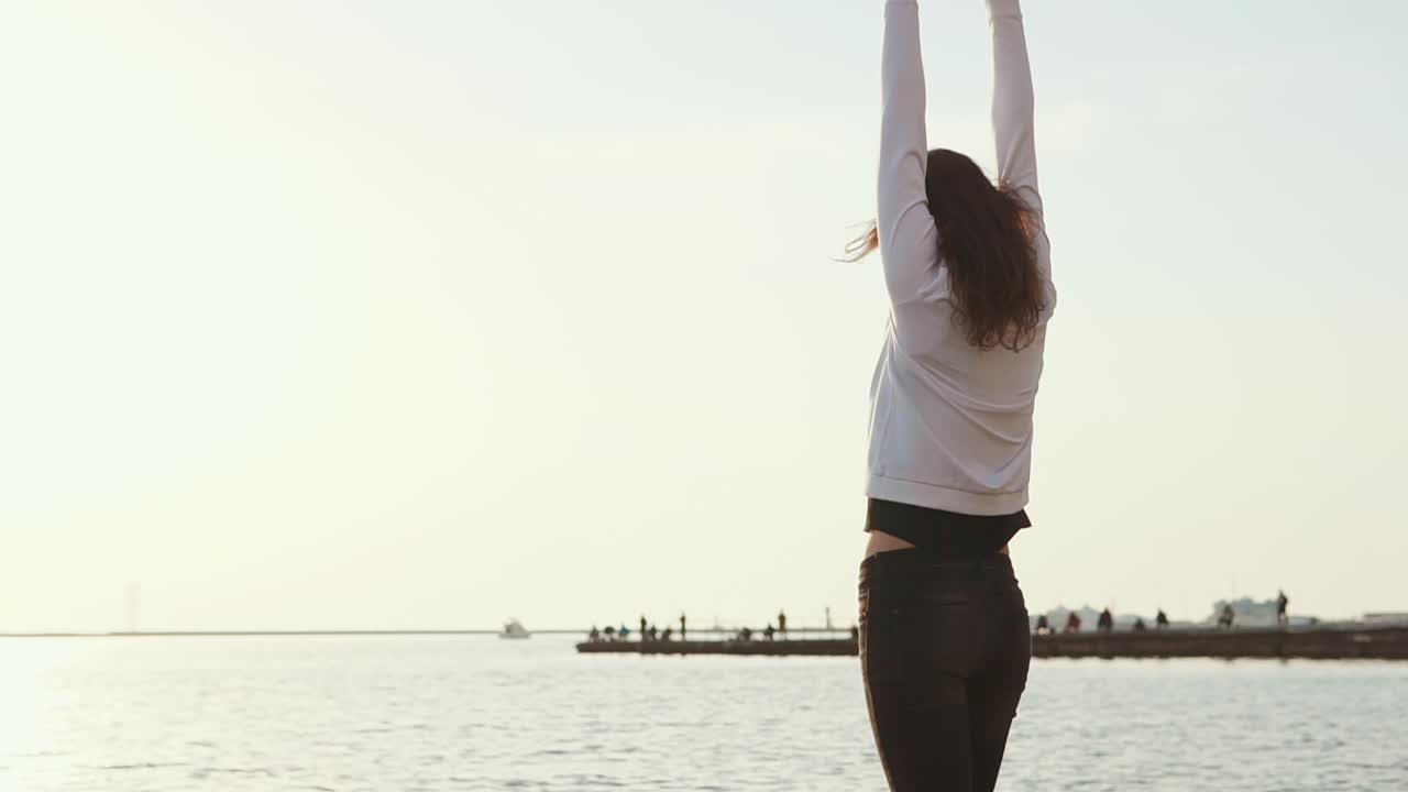 mujer disfrutando de la puesta de sol en la playa