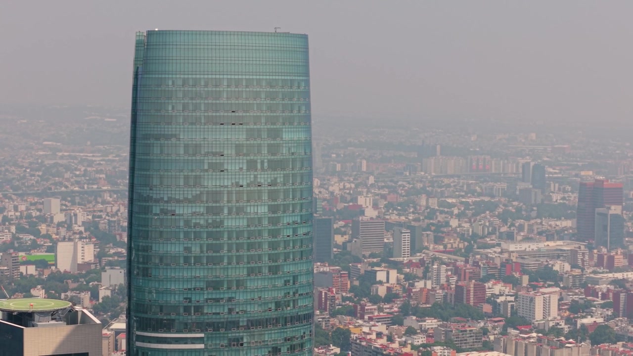 Panorámica de dron que muestra una torre prominente bajo la luz diurna brumosa.