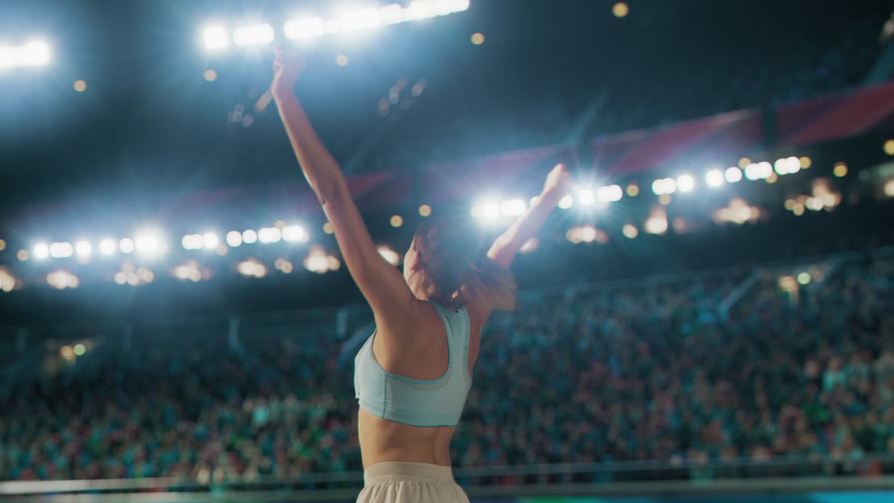 Portrait of Professional Female Athlete Happily Celebrating New Record on a Sport Championship with Stadium Crowd Cheering. Young Sportswoman Raising Arms Cheering. Winning, Victory, Success
