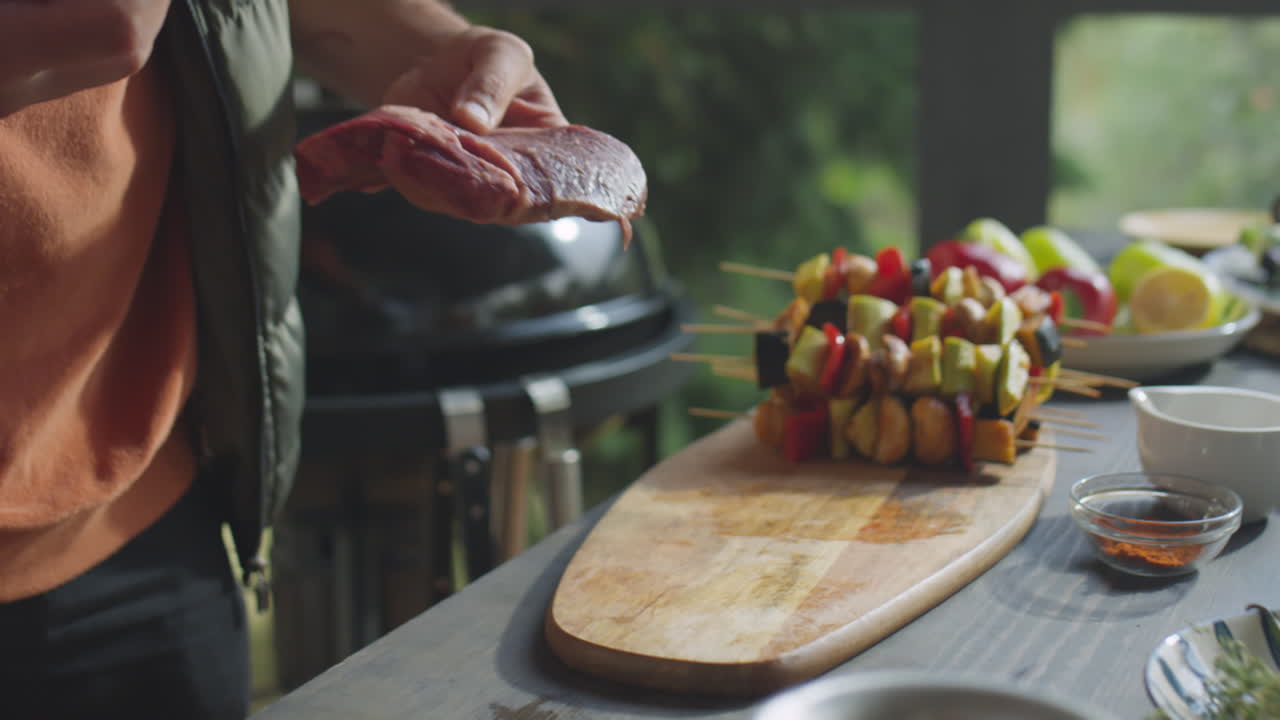 Preparing Meat Steaks for Grilling on Outdoor Terrace