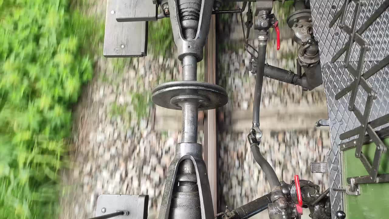 Coupling between two train cars on a moving train, seen from above, static shot