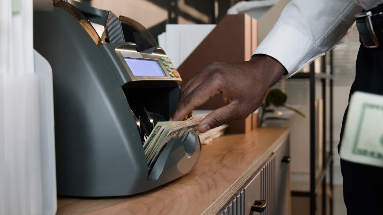 Person Counting Money Using a Bill Counter