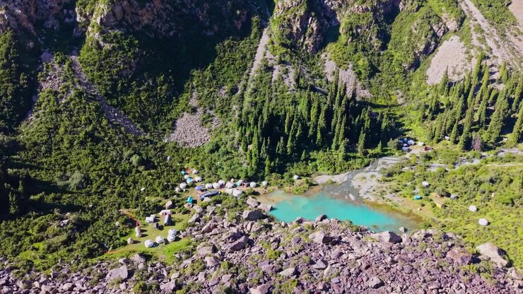 Drone che riprende con panoramica attorno al campo di yurte nomadi Sirota sul sentiero per il lago Ala-Kul