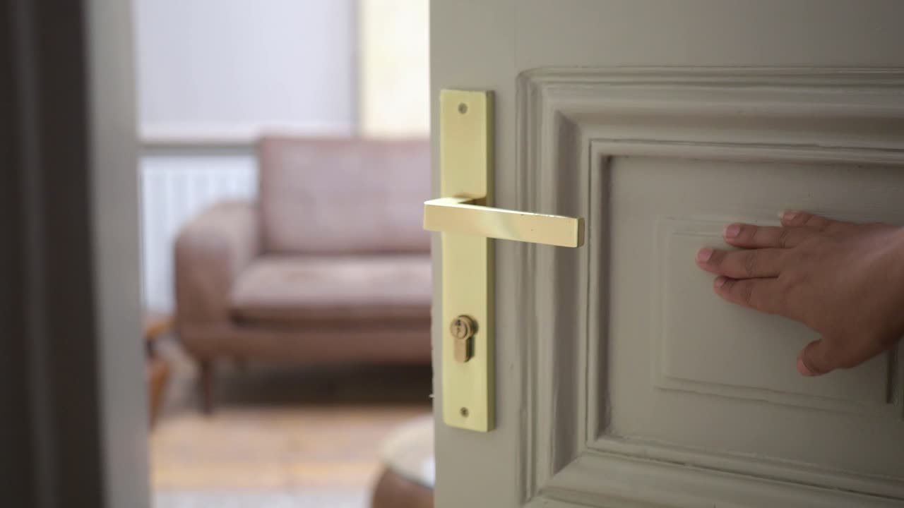 рука, тянущаяся за золотую дверную ручку.