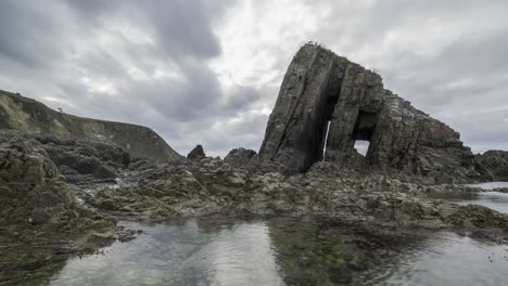 rocks and transparent seawater against cloudy sky