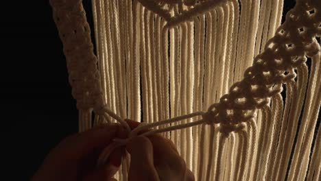 close-up of macrame wall hanging being crafted
