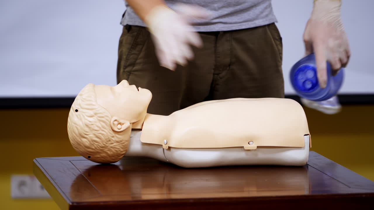 Instructor near mannequin in medical center. Trainer demonstrating cpr procedure on a medical doll. Healthcare and education concept.
