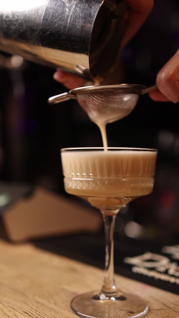 Versano un cocktail in un bicchiere