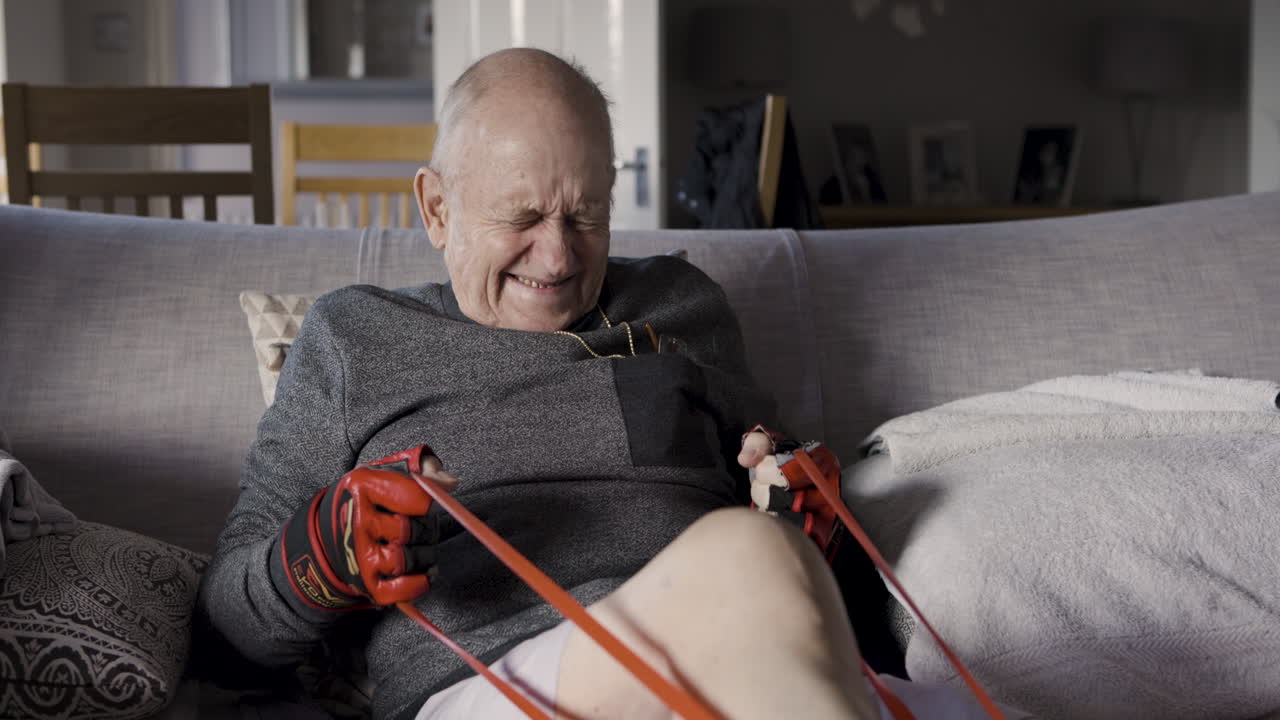 Elderly man exercising with resistance band at home