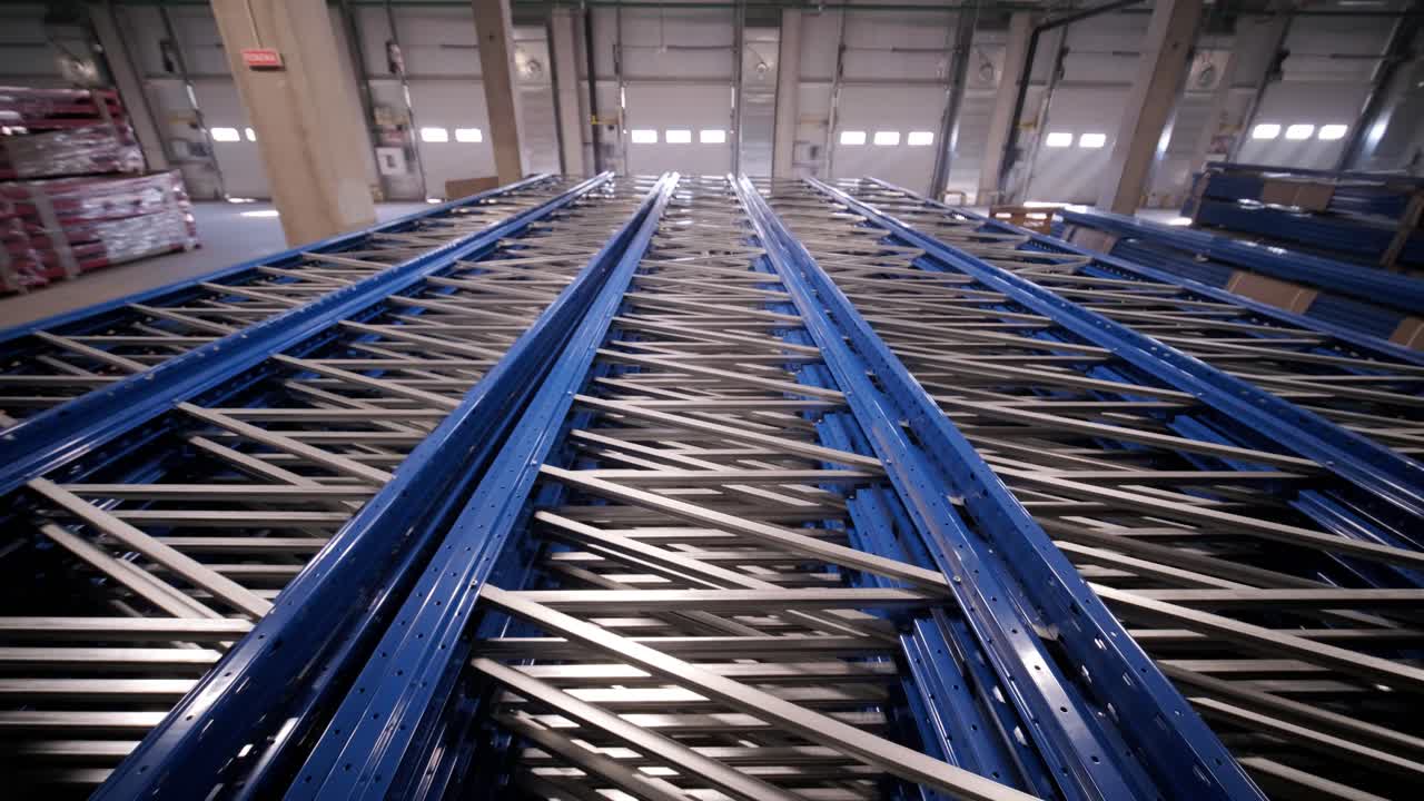 Big and modern warehouse under construction, featuring metal shelving and other industrial equipment.