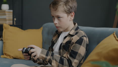 boy playing video games on couch