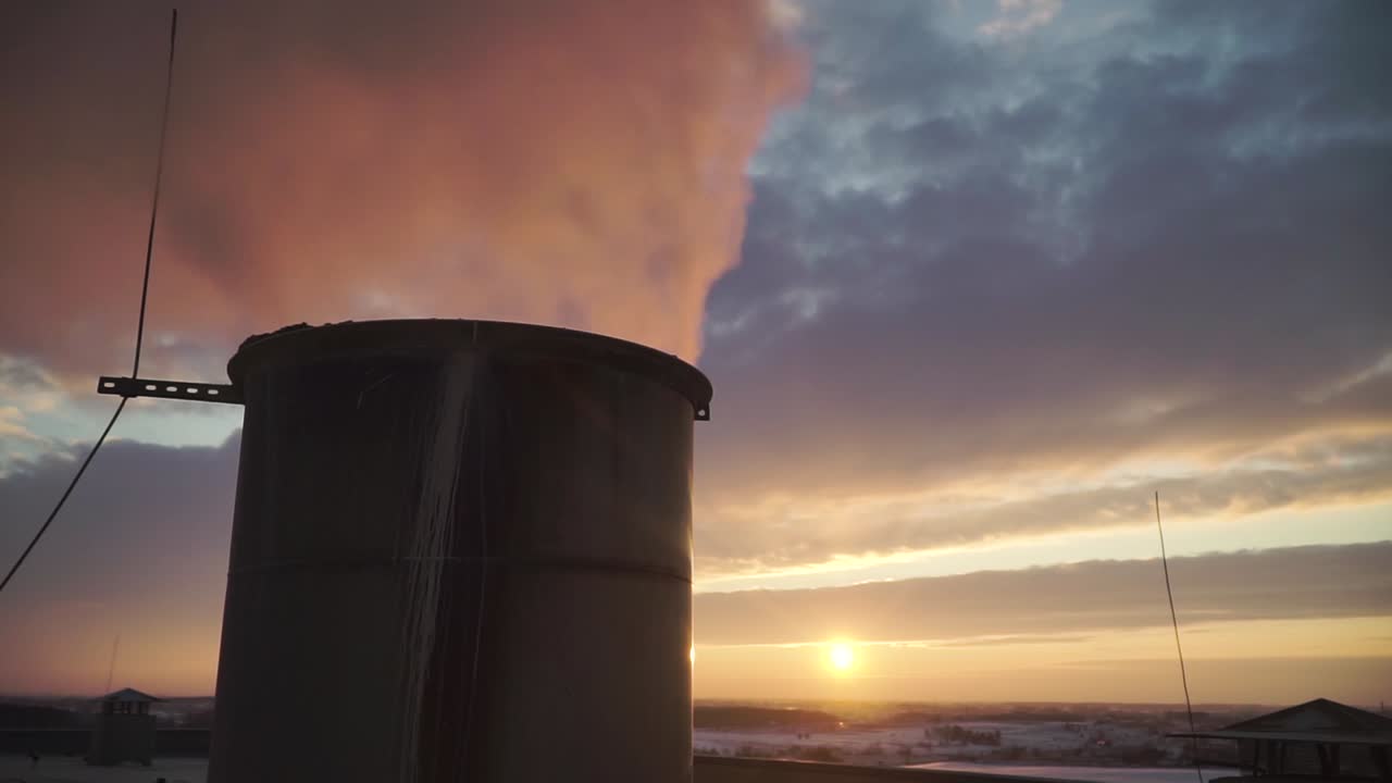 Fumo dal camino industriale nei raggi del tramonto