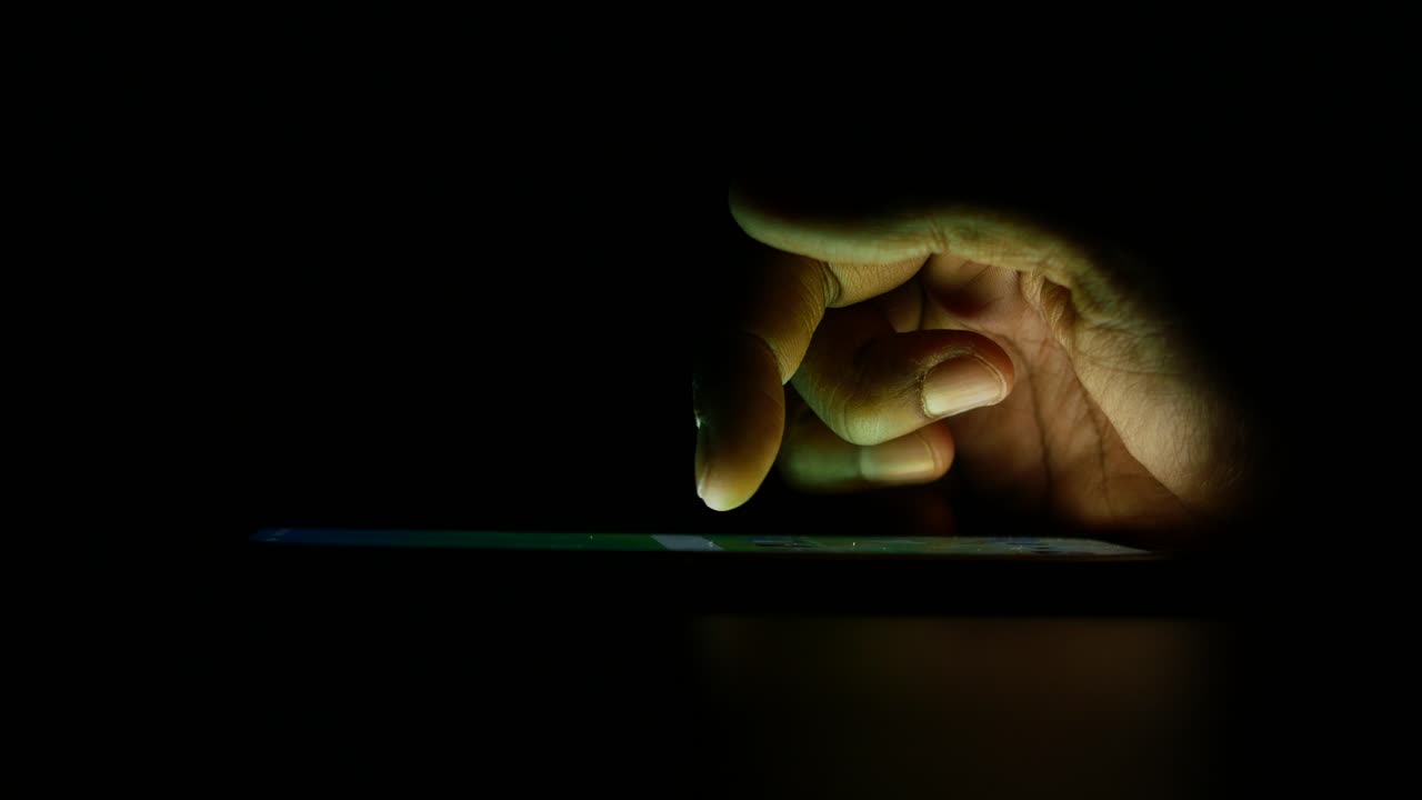 Mano che usa uno smartphone di notte