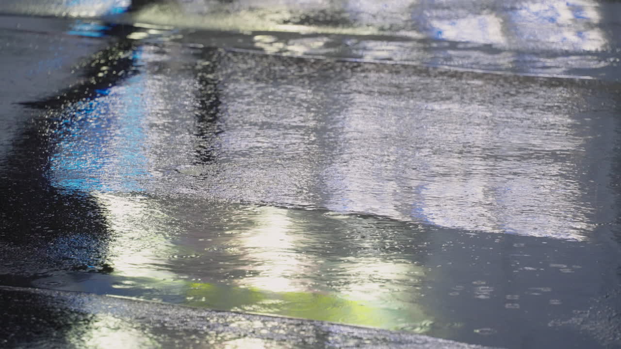 Silhouette Reflection On Rain Puddles Of A Person Walking Across The Asphalt Road In Tokyo, Japan